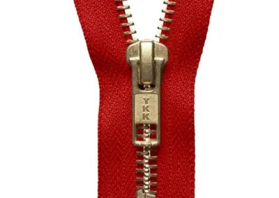 Red metal zipper with brass teeth and branded slider – for jeans, jackets and bags
