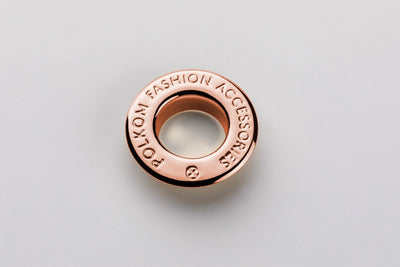 Œillet métallique avec inscription de marque en relief en or rose pour collections femme