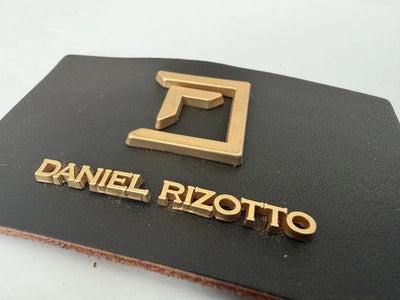 Premium ægte læderetiket med metal logo i mat guld – 8 × 5 cm