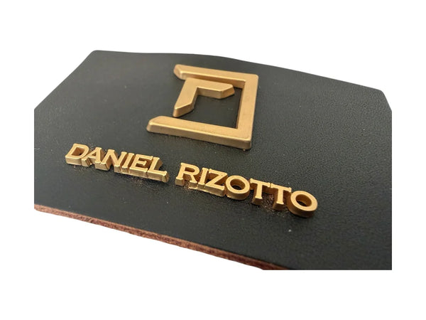 Premium etiketa iz pravega usnja z kovinskim logotipom v mat zlati barvi – 8 × 5 cm