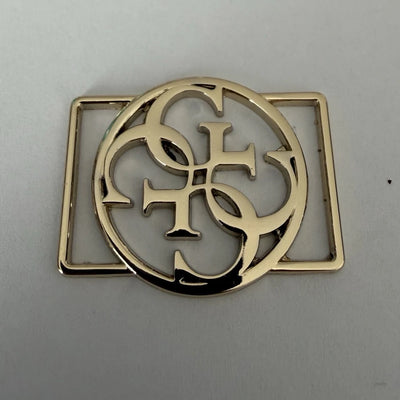 Logoplatta i metall i blankt guld med genombrutet monogram i cirkel och slitsar för 20 mm band