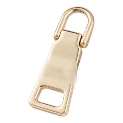 Trapezformet lynlåstrækker i metal med logo i lyst guld
