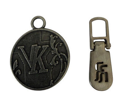 Metallhängen för dragkedja med logotyp – laserskuret monogram och formsprutad djup relief