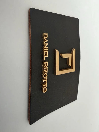 Læderetiket med præget metal logo og bogstaver – premium branding til tøj og tasker